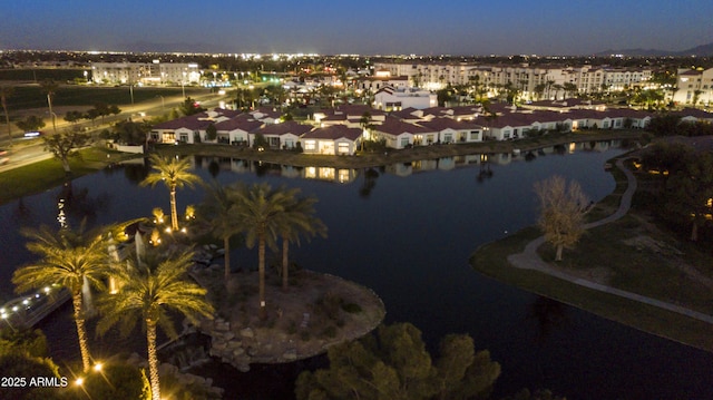 aerial view at dusk featuring a water view