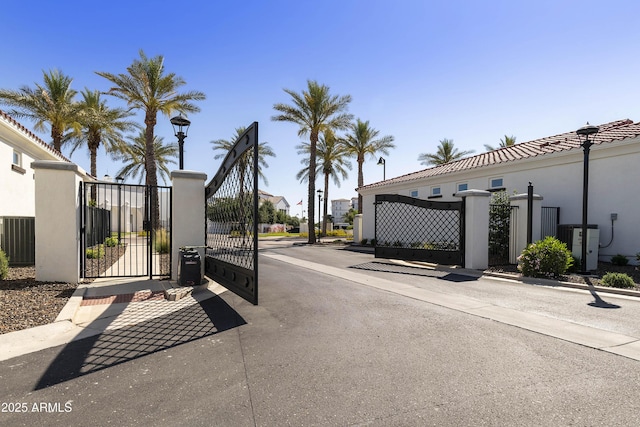 view of gate with fence and central air condition unit