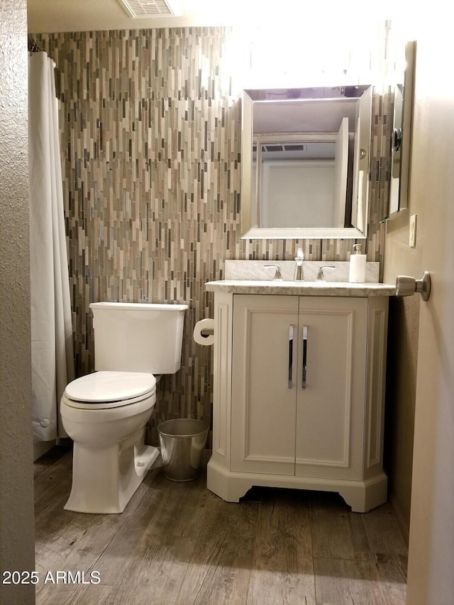 full bath with wood finished floors, toilet, and vanity