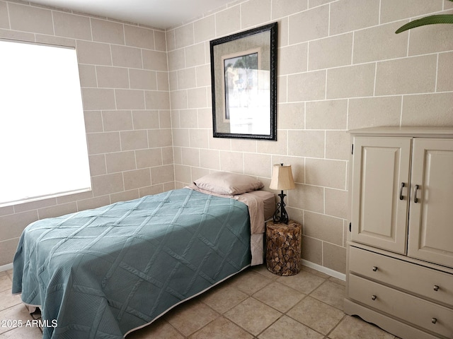 bedroom with tile walls and light tile patterned flooring