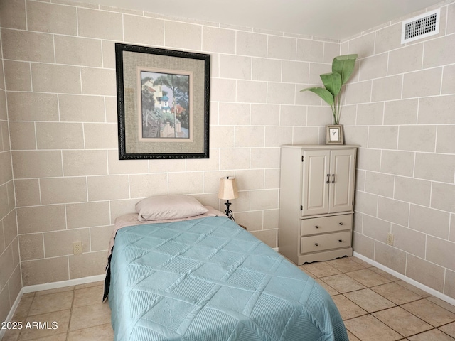 bedroom with tile walls and light tile patterned floors