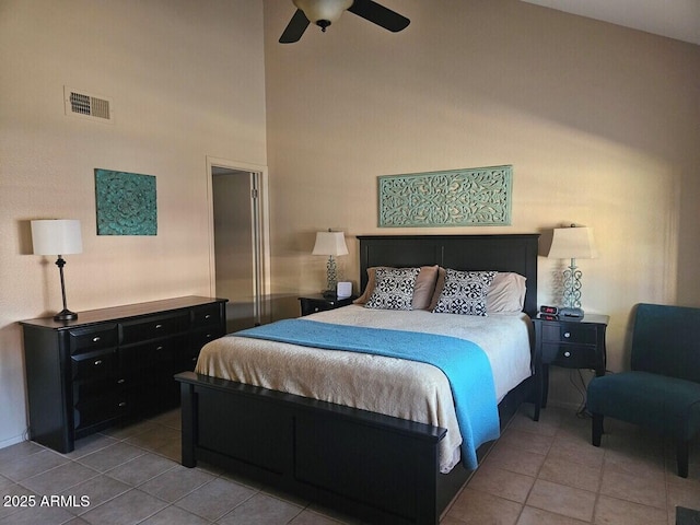 bedroom featuring light tile patterned floors, a towering ceiling, and ceiling fan