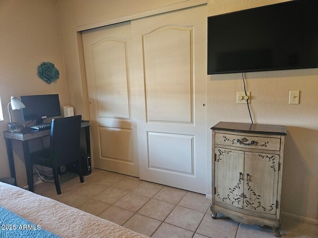 bedroom featuring light tile patterned floors and an office area