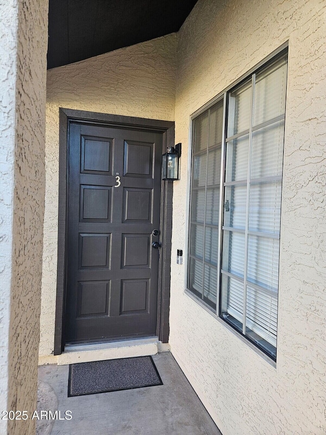 property entrance featuring stucco siding