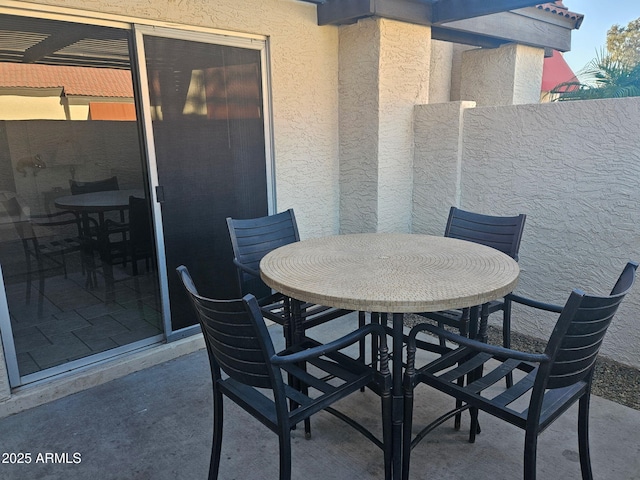 view of patio featuring outdoor dining area and fence