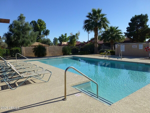 community pool featuring fence and a patio area
