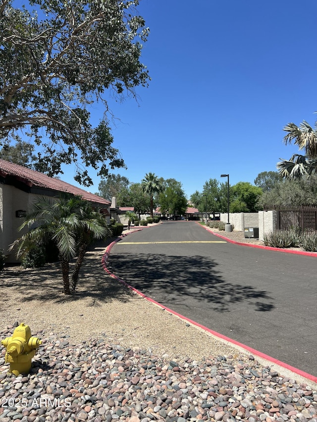 view of asphalt street featuring street lighting
