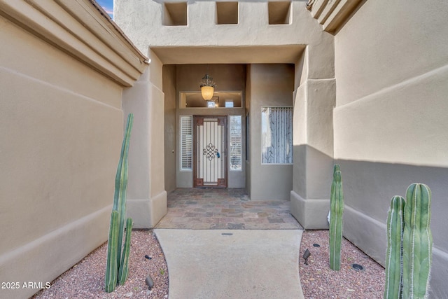 view of exterior entry featuring stucco siding