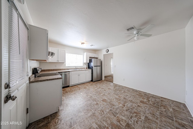 kitchen featuring ceiling fan, sink, stainless steel appliances, and white cabinets