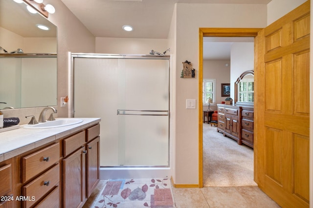 bathroom with tile patterned floors, a shower with door, and vanity