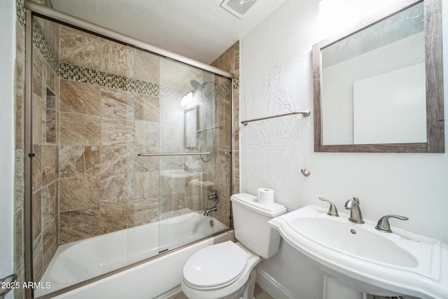 full bathroom featuring sink, combined bath / shower with glass door, and toilet