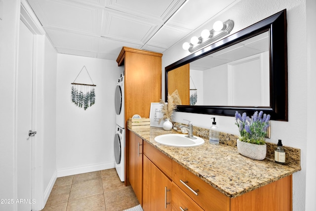 7350 N Via Paseo Del Sur Unit O202, Scottsdale, AZ 85258 - bathroom featuring baseboards, stacked washer / dryer, tile patterned floors, and vanity