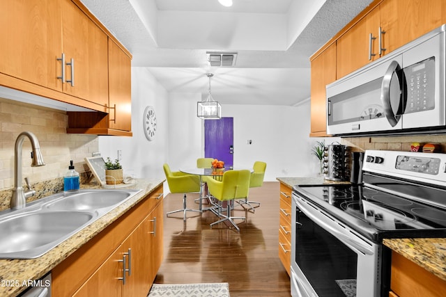 7350 N Via Paseo Del Sur Unit O202, Scottsdale, AZ 85258 - kitchen featuring visible vents, dark wood-style flooring, a sink, appliances with stainless steel finishes, and backsplash
