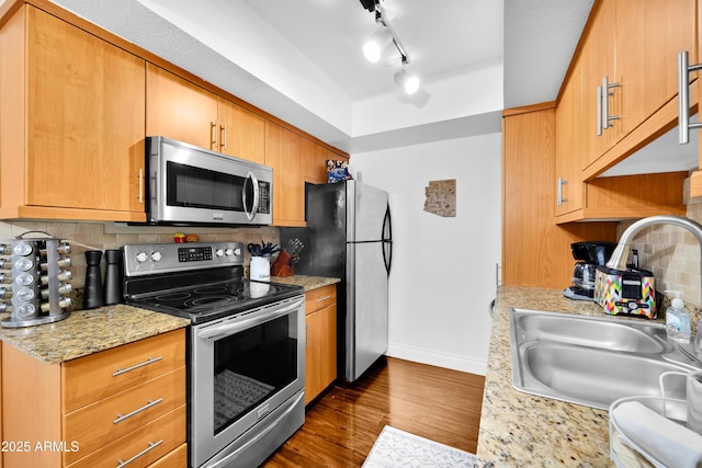 7350 N Via Paseo Del Sur Unit O202, Scottsdale, AZ 85258 - kitchen featuring backsplash, a sink, baseboards, stainless steel appliances, and dark wood-type flooring