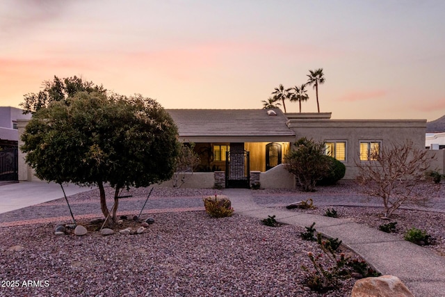 view of front of house with a tiled roof and stucco siding