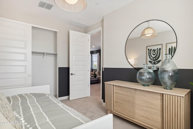 bedroom featuring light carpet and a closet