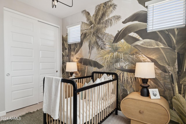 bedroom with carpet flooring, a closet, and a nursery area