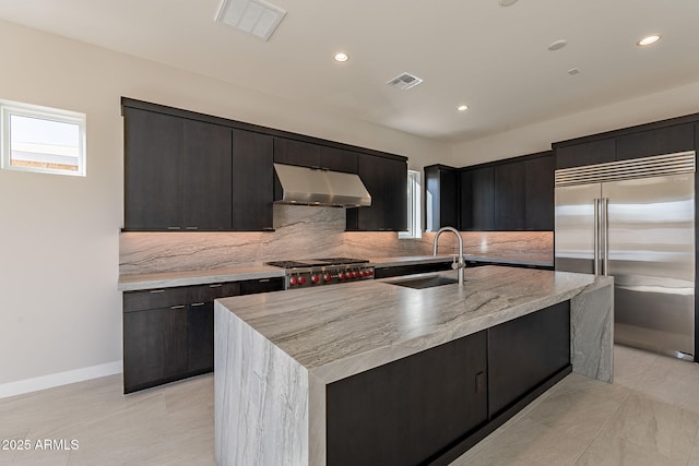 kitchen with appliances with stainless steel finishes, ventilation hood, a center island with sink, and sink