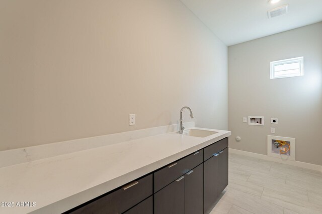 washroom with sink, cabinets, washer hookup, hookup for an electric dryer, and gas dryer hookup