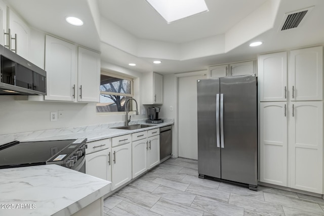 3204 N Jay St, Chandler, AZ 85225 - kitchen with stainless steel appliances, white cabinetry, light stone counters, recessed lighting, and a tray ceiling