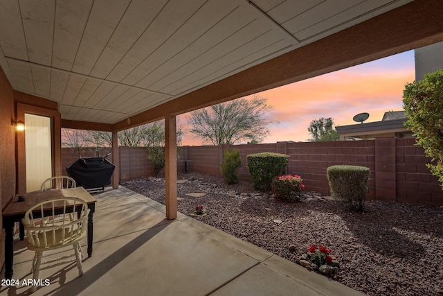 patio terrace at dusk featuring area for grilling