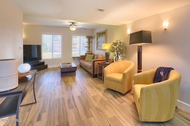 living room with ceiling fan and light hardwood / wood-style flooring