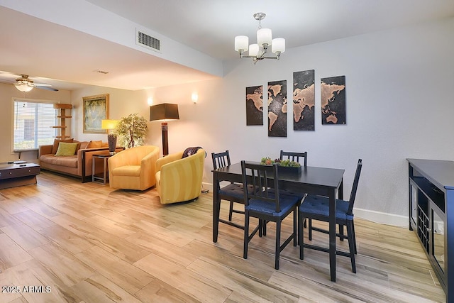 dining room featuring ceiling fan with notable chandelier and light wood-type flooring