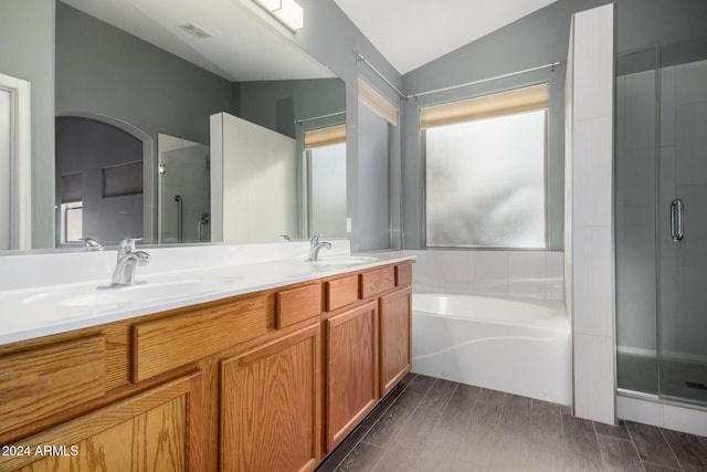 bathroom with vaulted ceiling, independent shower and bath, and vanity