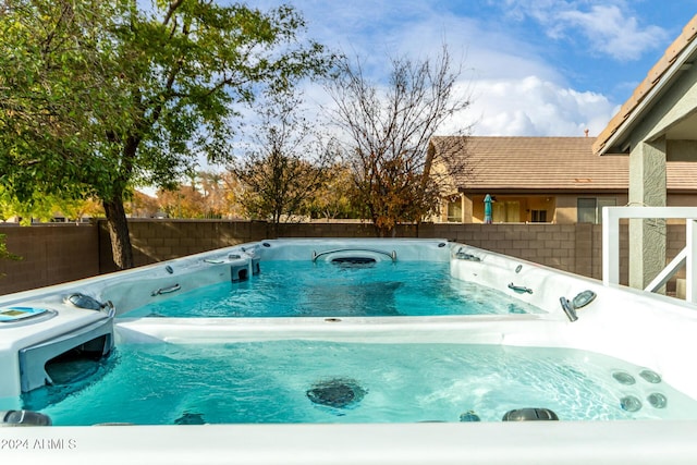 view of swimming pool featuring a hot tub