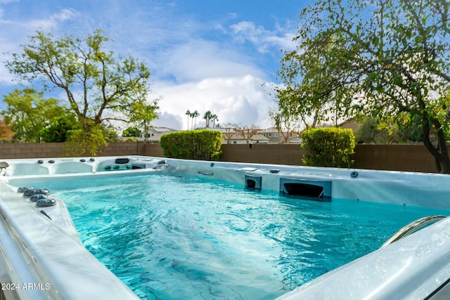 view of swimming pool featuring a hot tub