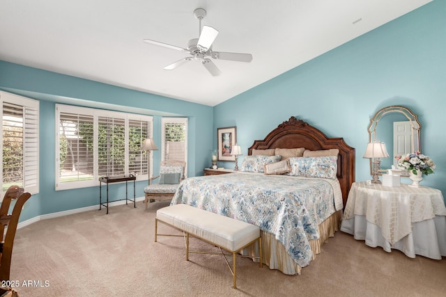 bedroom featuring a ceiling fan, light colored carpet, vaulted ceiling, and baseboards