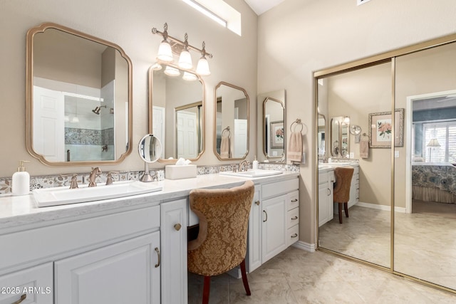 full bathroom featuring connected bathroom, a shower stall, a sink, and double vanity