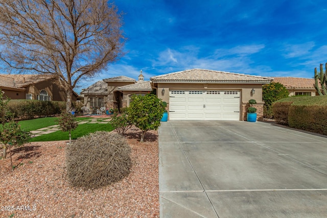 single story home featuring a garage, concrete driveway, a tile roof, and stucco siding