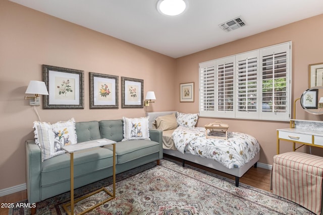 living area with baseboards, visible vents, and wood finished floors