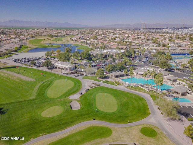 drone / aerial view with golf course view, a residential view, and a water and mountain view