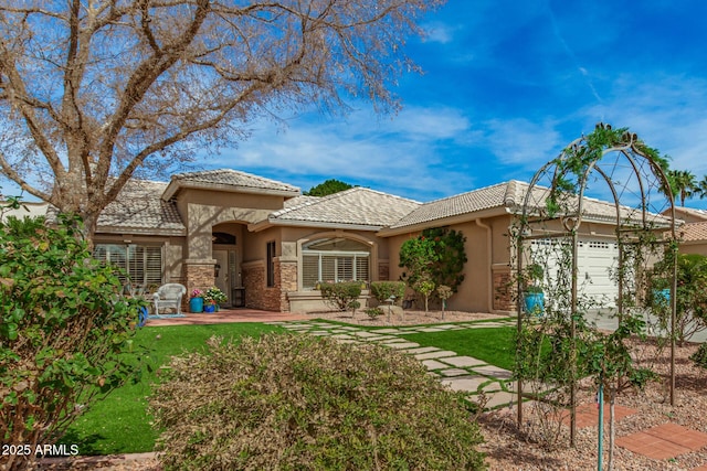 view of front facade featuring a garage, a tile roof, and stucco siding