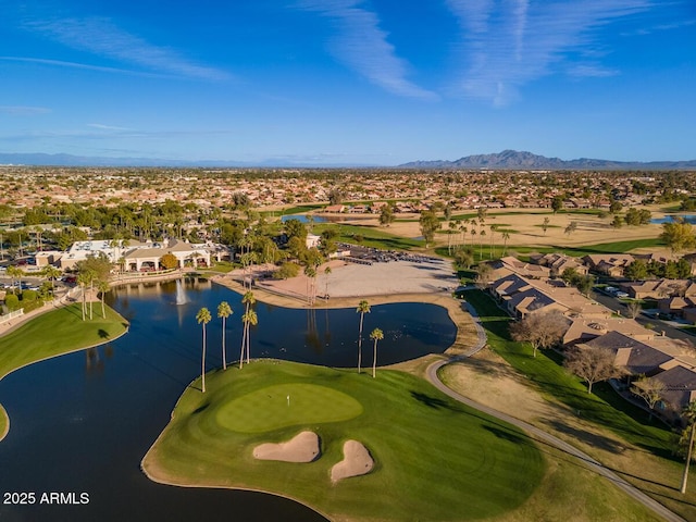 drone / aerial view featuring view of golf course, a residential view, and a water and mountain view