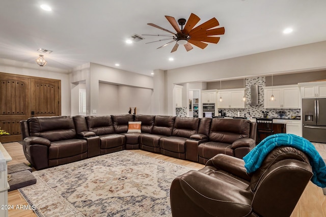 living room with ceiling fan and light wood-type flooring