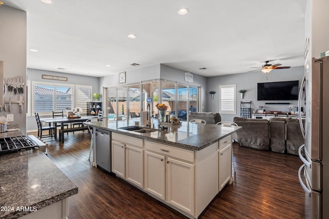 kitchen with a kitchen island with sink, dark hardwood / wood-style floors, ceiling fan, and stainless steel appliances