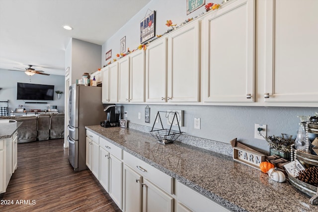 kitchen featuring light stone countertops, white cabinetry, dark hardwood / wood-style flooring, and ceiling fan