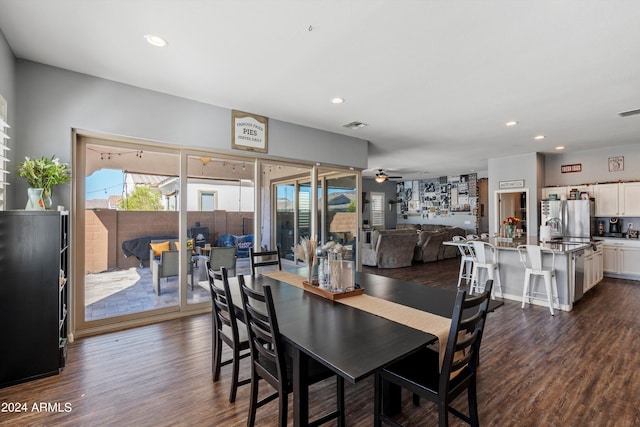 dining area featuring a fireplace, dark hardwood / wood-style flooring, and ceiling fan