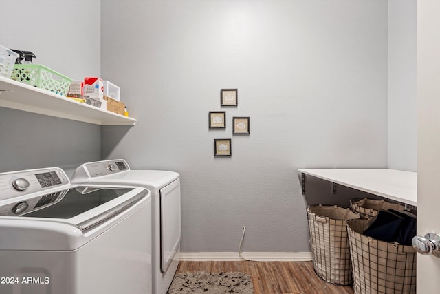 clothes washing area featuring hardwood / wood-style flooring and washing machine and dryer