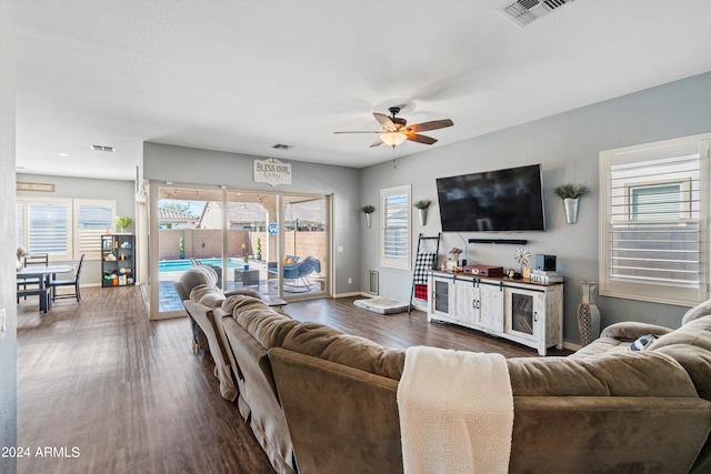 living room featuring ceiling fan and dark hardwood / wood-style floors