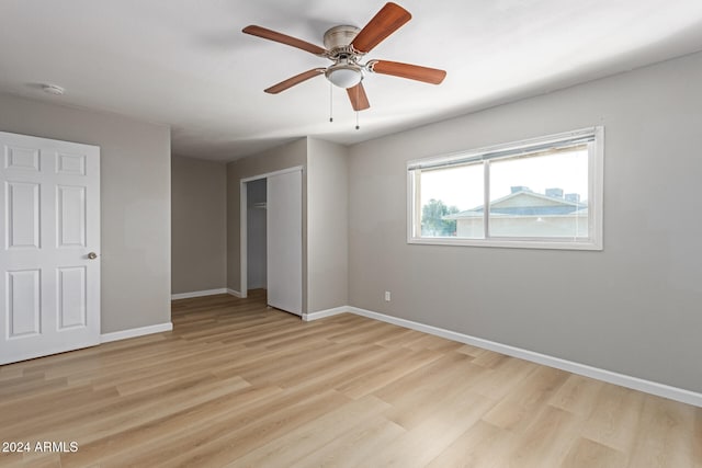 unfurnished bedroom with light hardwood / wood-style flooring, a closet, and ceiling fan