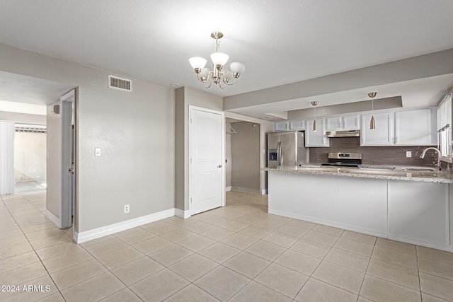 kitchen with appliances with stainless steel finishes, pendant lighting, decorative backsplash, and white cabinets