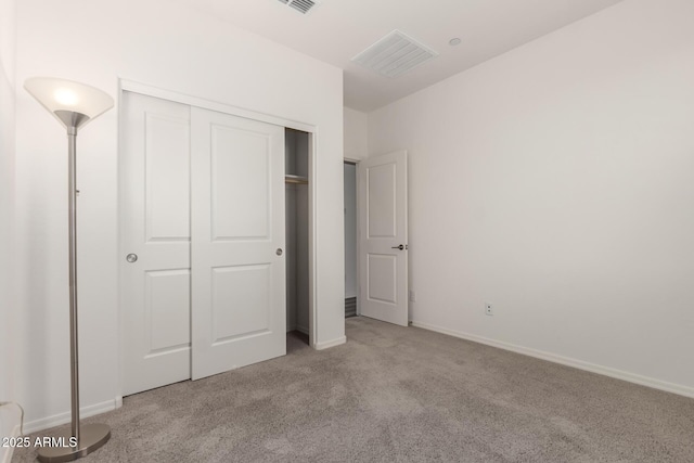 unfurnished bedroom with light carpet and a closet