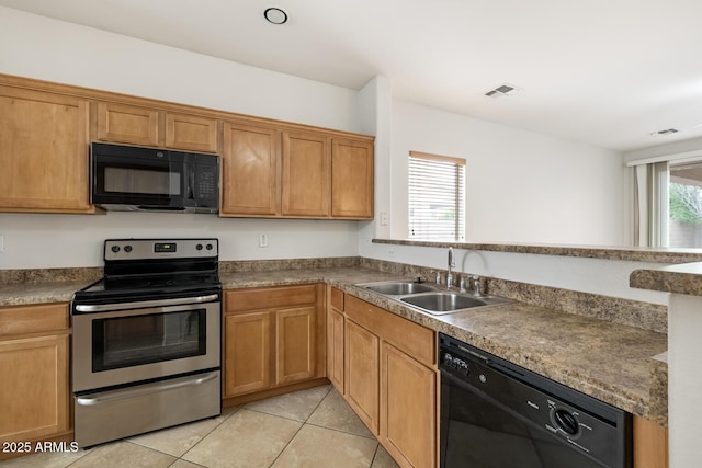 11702 W Lincoln St, Avondale, AZ 85323 - kitchen featuring black appliances, a sink, light tile patterned floors, a peninsula, and brown cabinets