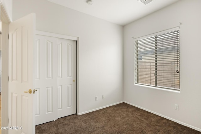 11702 W Lincoln St, Avondale, AZ 85323 - unfurnished bedroom with dark carpet, baseboards, and a closet