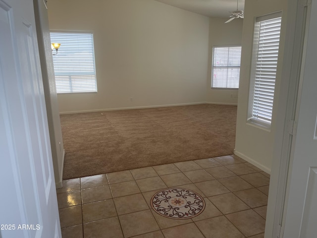 11109 W Amelia Ave, Avondale, AZ 85392 - empty room featuring light colored carpet, light tile patterned flooring, and a ceiling fan