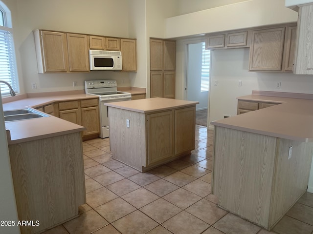 11109 W Amelia Ave, Avondale, AZ 85392 - kitchen featuring white appliances, a towering ceiling, light brown cabinetry, light tile patterned floors, and a center island